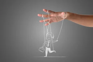 Diferențierea sinelui ilustrată printr-un personaj controlat de o mână exterioară, simbol al presiunilor sociale și al pierderii autenticității.